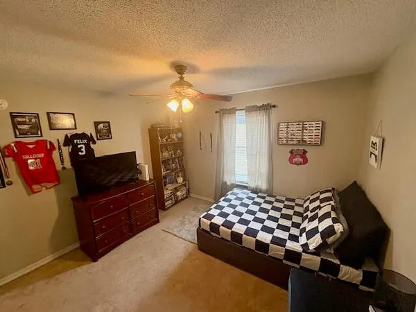 a bedroom with a bed and dresser with mirror