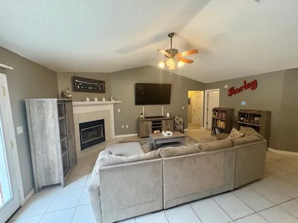a living room with furniture a fireplace and a flat screen tv