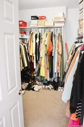 a view of walk in closet with clothes