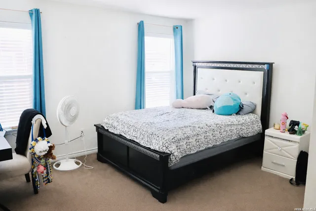 a bedroom with a bed and a large window