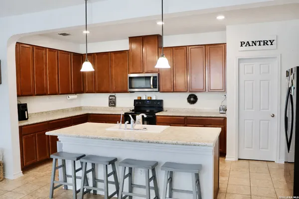 a kitchen with stainless steel appliances granite countertop a sink refrigerator and cabinets