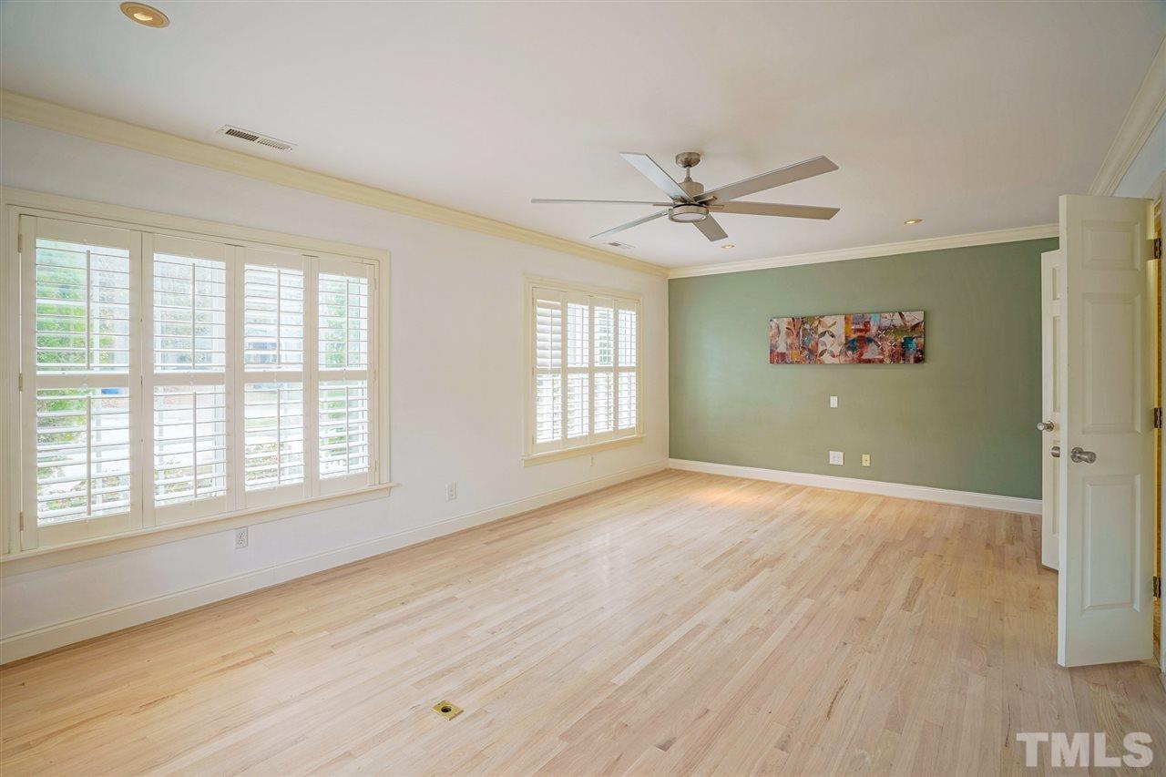 2606 Mayview Road Raleigh, NC 27607 - Photo 11 of 26 an empty room with wooden floor ceiling fan and windows