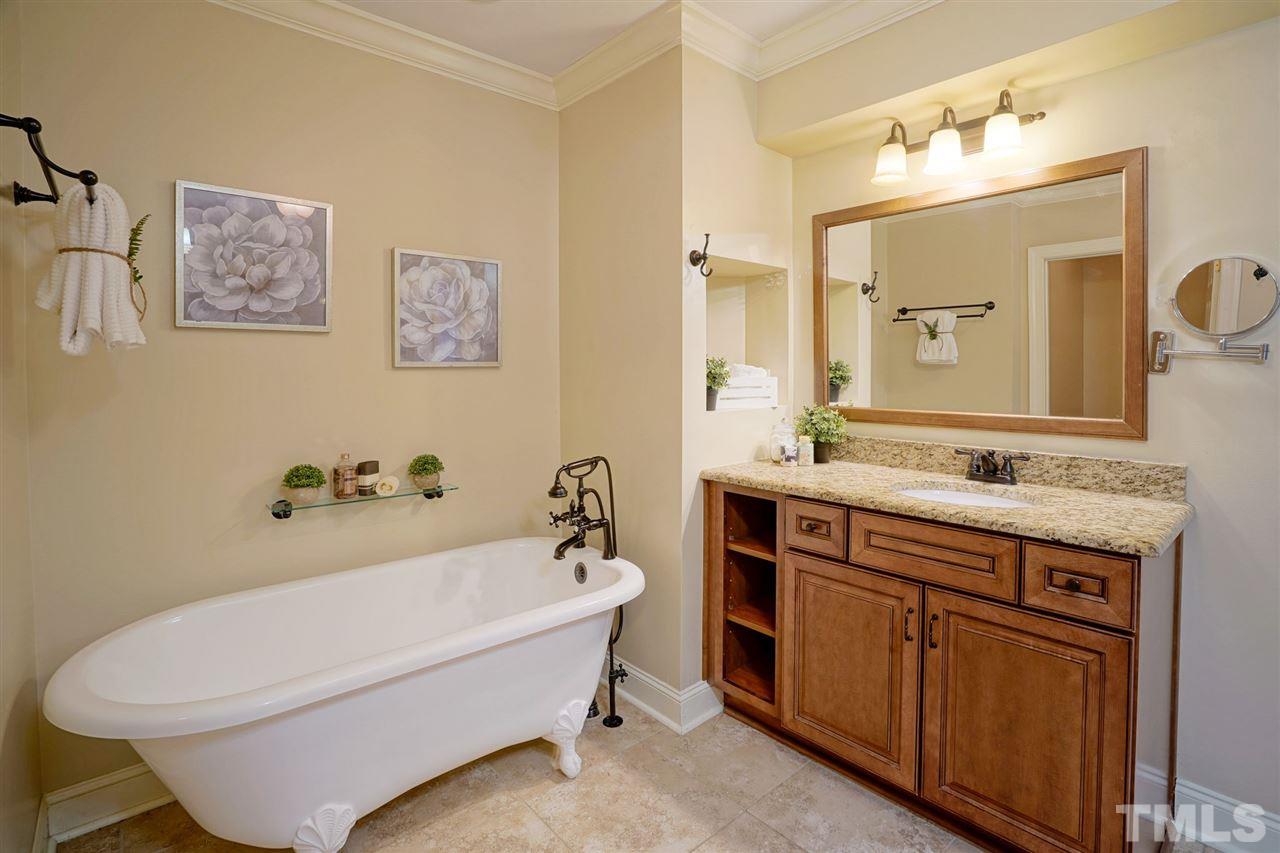 2606 Mayview Road Raleigh, NC 27607 - Photo 13 of 26 a bathroom with a bathtub a sink and a mirror