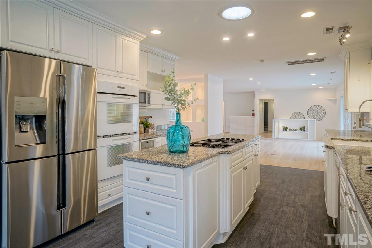 2606 Mayview Road Raleigh, NC 27607 - Photo 9 of 26 a kitchen with stainless steel appliances granite countertop a refrigerator sink and white cabinets