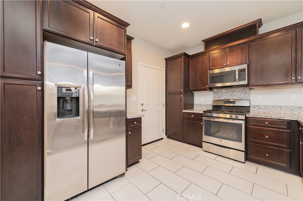 6014 Eucalyptus Avenue Chino, CA 91710 - Photo 5 of 16 a kitchen with granite countertop stainless steel appliances and a refrigerator