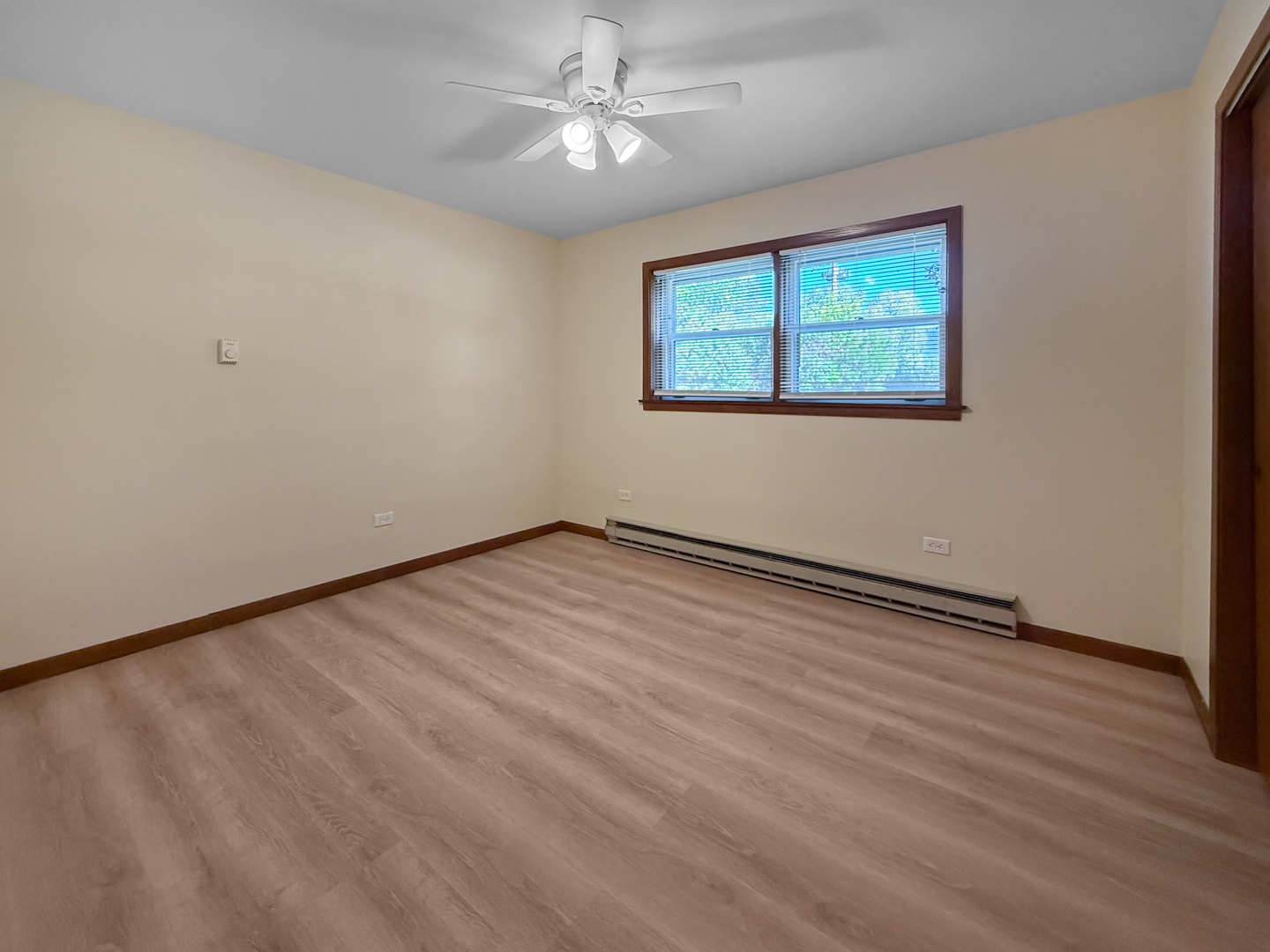 2025 Maple Road, Unit 1E Homewood, IL 60430 - Photo 8 of 12 an empty room with wooden floor chandelier fan and windows