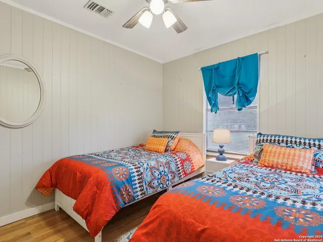 a bedroom with two beds and a potted plant
