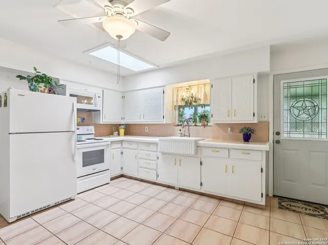 a kitchen with white cabinets and white appliances