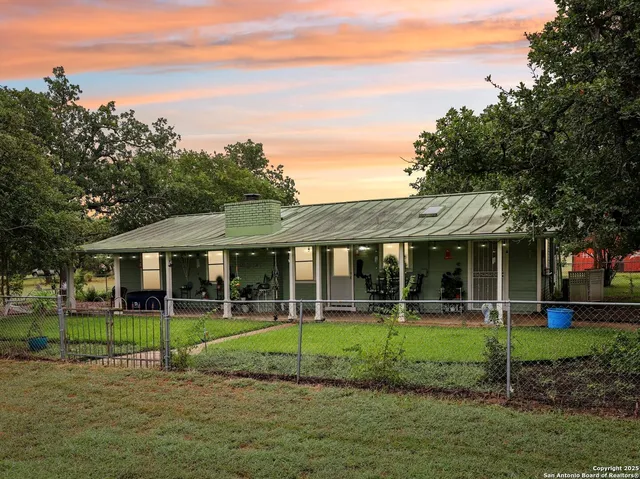 a view of backyard with a table and chairs and potted plants