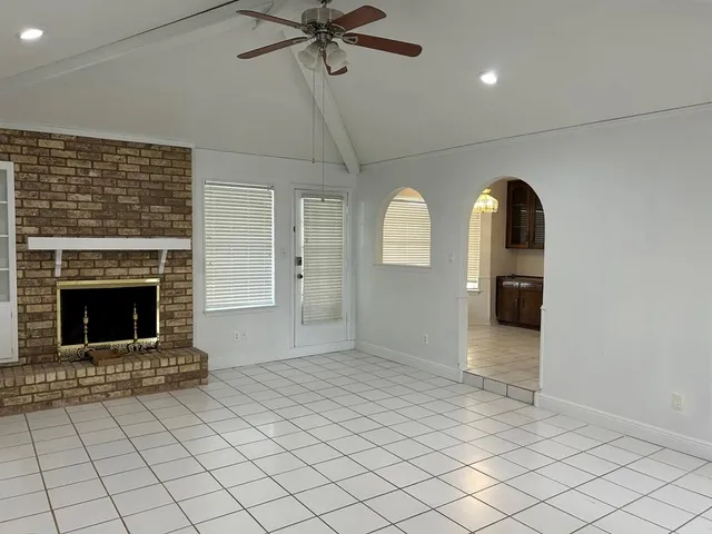 an empty room with windows and fireplace