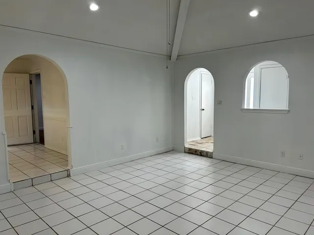 an empty room with mirror and windows