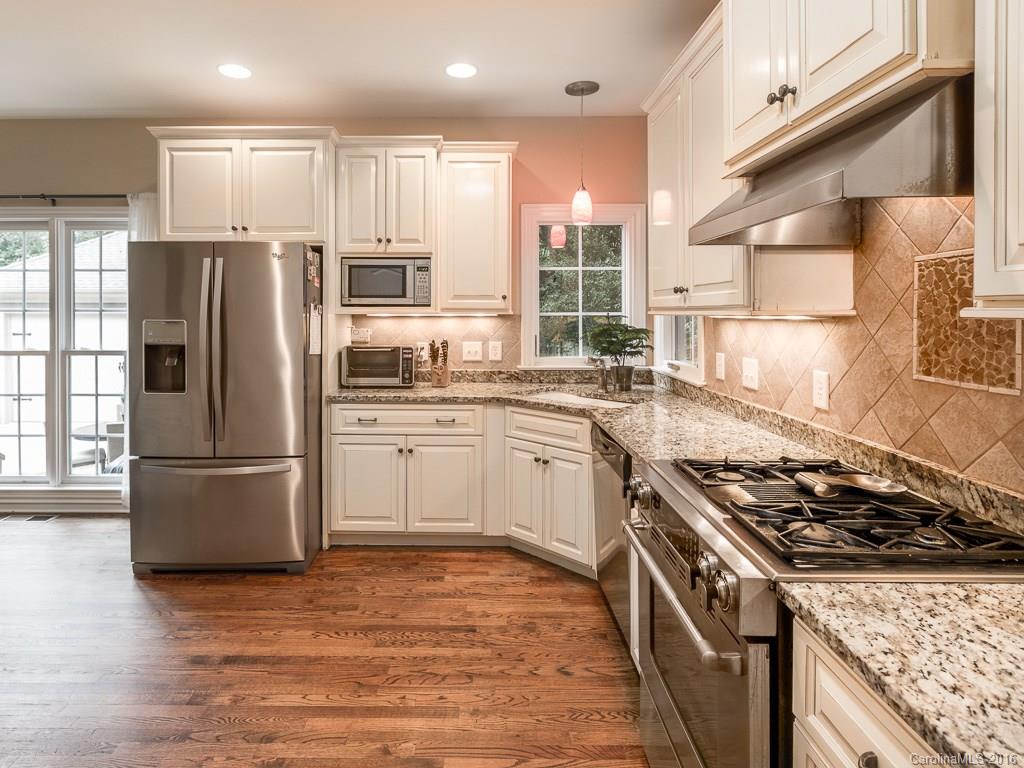 919 Millbrook Road Charlotte, NC 28211 - Photo 3 of 20 a kitchen with wooden cabinets stainless steel appliances and sink