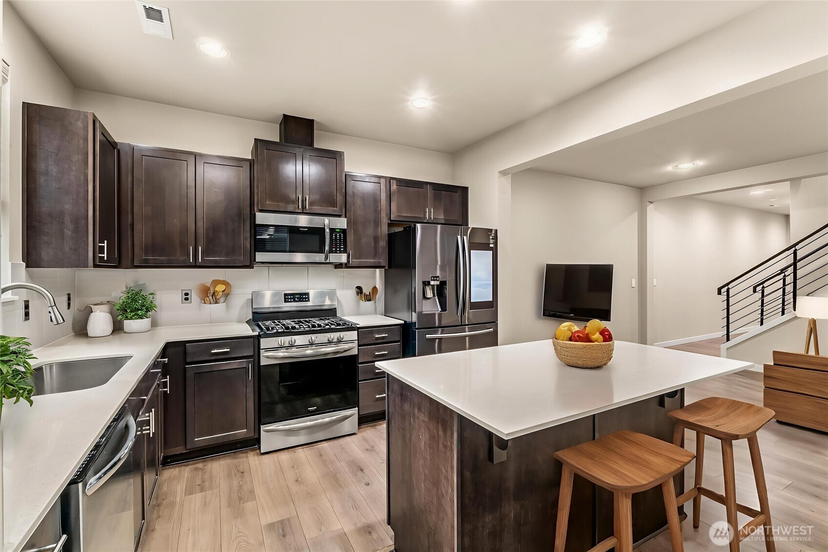 19326 37th Avenue Southeast, Unit C Bothell, WA 98012 - Photo 8 of 32 a kitchen with stainless steel appliances a stove a sink a microwave a dining table and chairs