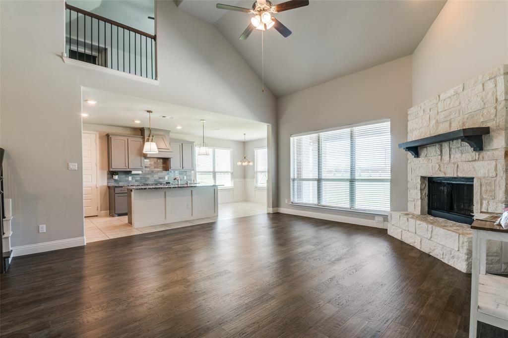 1133 Barrix Drive Forney, TX 75126 - Photo 28 of 35 a view of an empty room with wooden floor and a kitchen