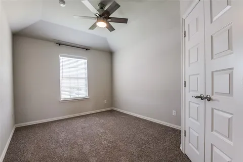 an empty room with a window and a fan