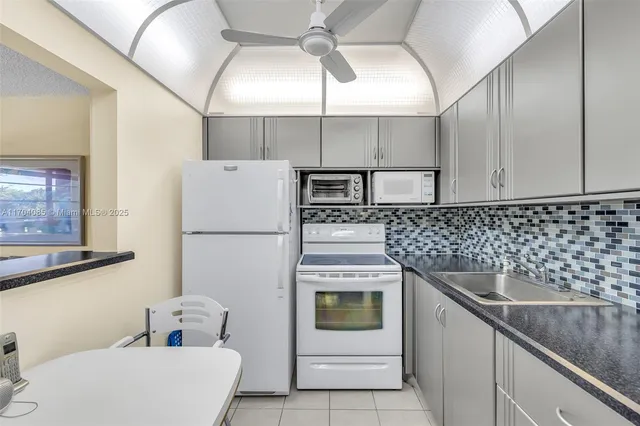 a bathroom with a granite countertop toilet sink and mirror