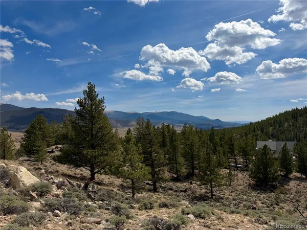 a view of a dry mountains and green field