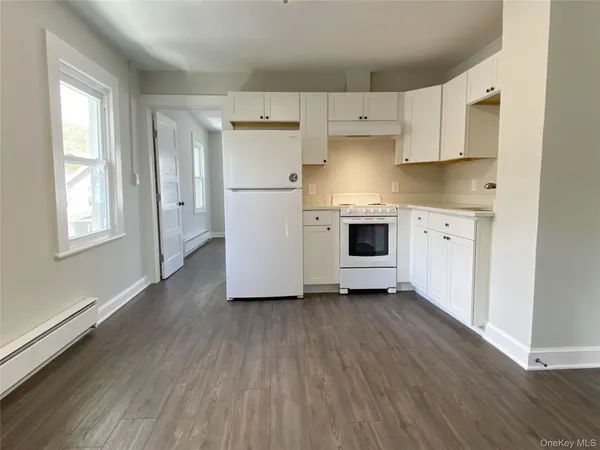 a view of kitchen with wooden floor and electronic appliances