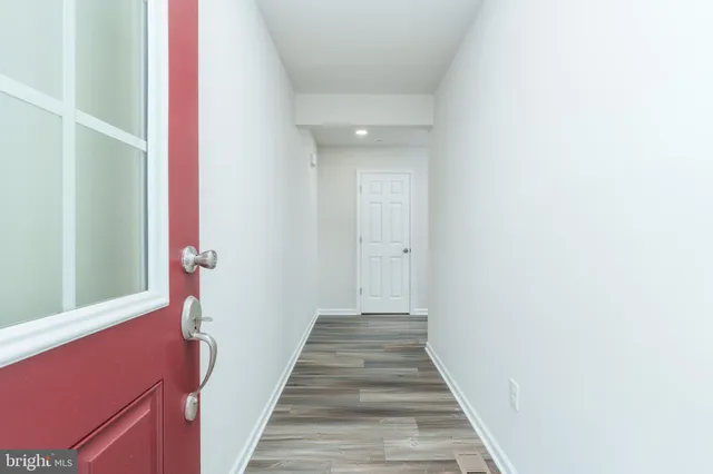 a view of a hallway with wooden floor and staircase