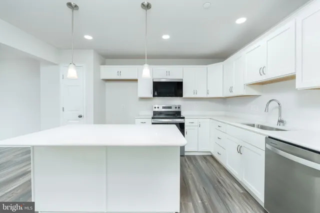 a kitchen with granite countertop a sink a stove and cabinets