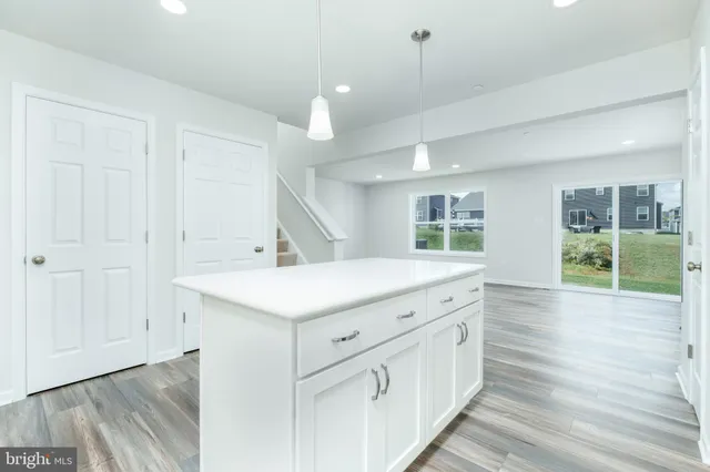 a view with center island wooden floor and windows