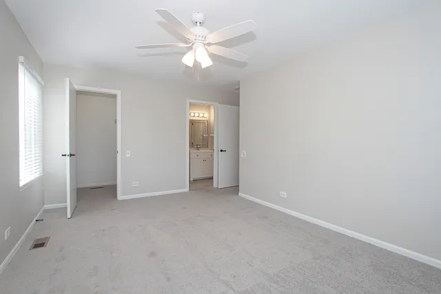 an empty room with fan and entrance