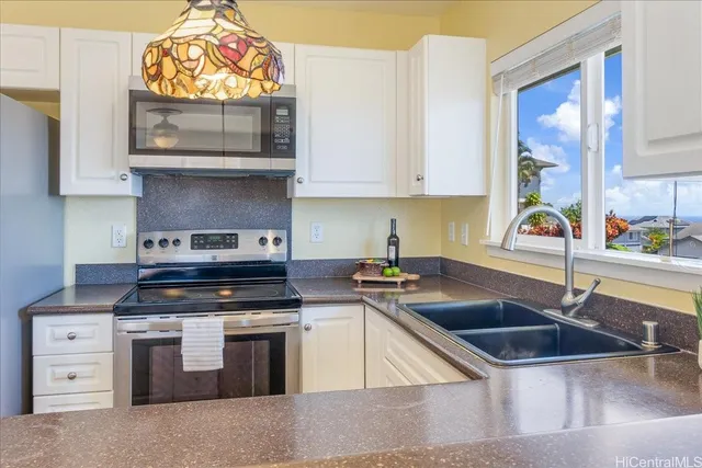 a kitchen with stainless steel appliances granite countertop a sink and a stove