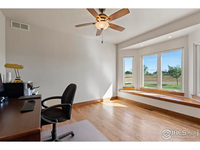 a view of a workspace with furniture and a window