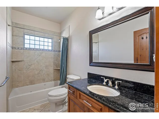 a bathroom with a granite countertop sink toilet a mirror and shower