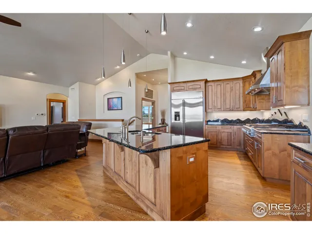 a kitchen with stainless steel appliances kitchen island granite countertop a stove a sink and a refrigerator
