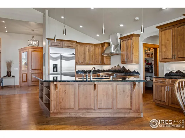 a kitchen with stainless steel appliances granite countertop a refrigerator a stove and a sink