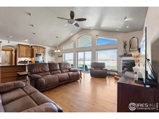 a living room with furniture kitchen view and a large window