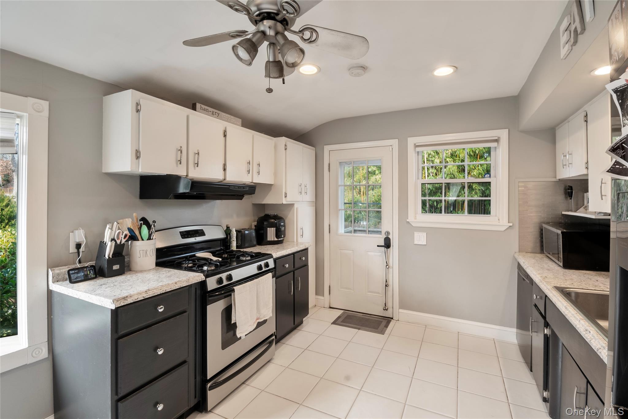 277 Horseblock Road Farmingville, NY 11738 - Photo 5 of 28 Kitchen with stainless steel appliances, white cabinets, under cabinet range hood, ceiling fan, and light tile patterned floors