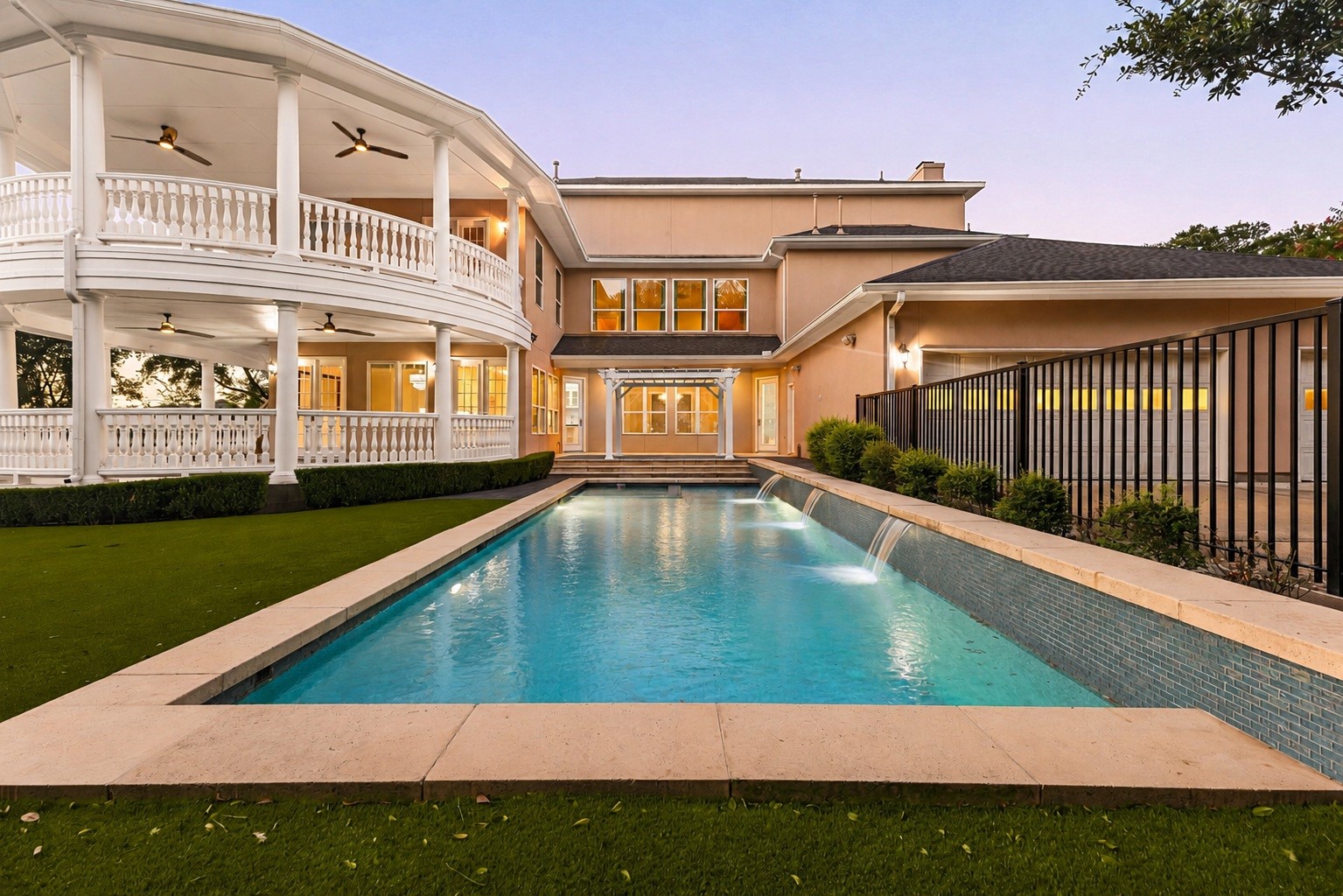 6039 Franz Road Katy, TX 77493 - Photo 35 of 49 The pool's water features glow beside a tiled travertine deck, with the home's warmly lit interior and covered porches creating an ideal setting for evening entertaining.