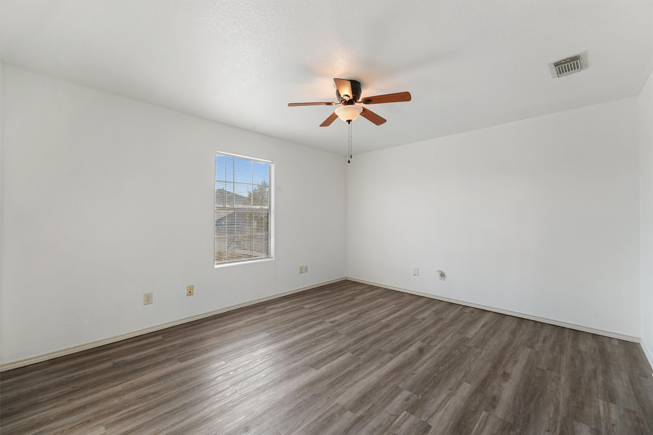 3114 Trinity Joe Lane Humble, TX 77396 - Photo 20 of 28 an empty room with wooden floor ceiling fan and windows