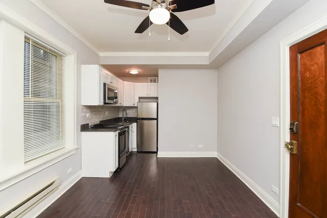 a kitchen with a refrigerator and white cabinets
