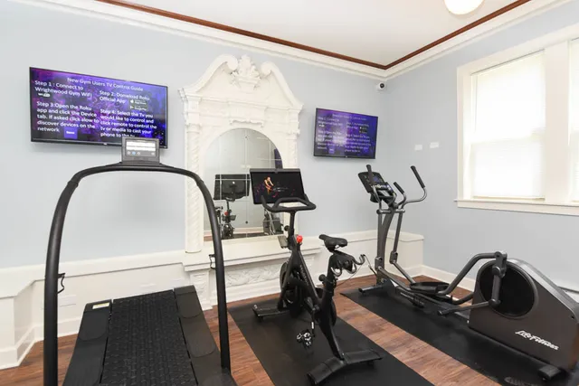 a room with gym equipment and wooden floor