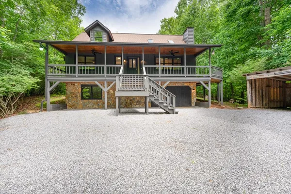 a view of a house with wooden deck and a yard