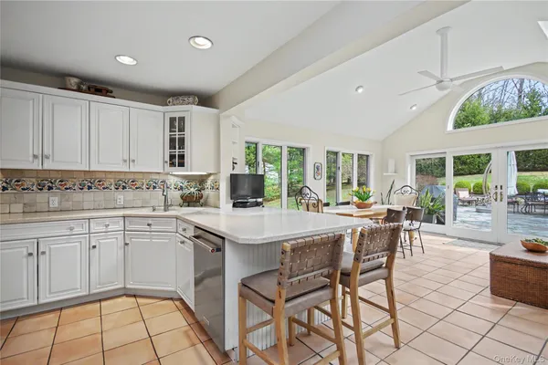 a kitchen with stainless steel appliances granite countertop a stove top oven a sink dishwasher and white cabinets with wooden floor