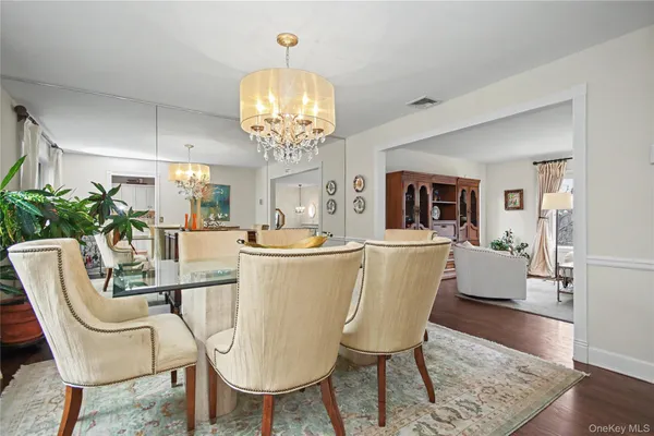 a dining room with furniture a chandelier and wooden floor