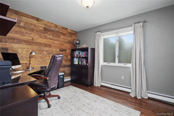 a view of a workspace with furniture and a window