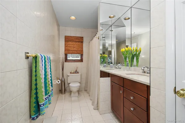a bathroom with a granite countertop sink a toilet and a mirror