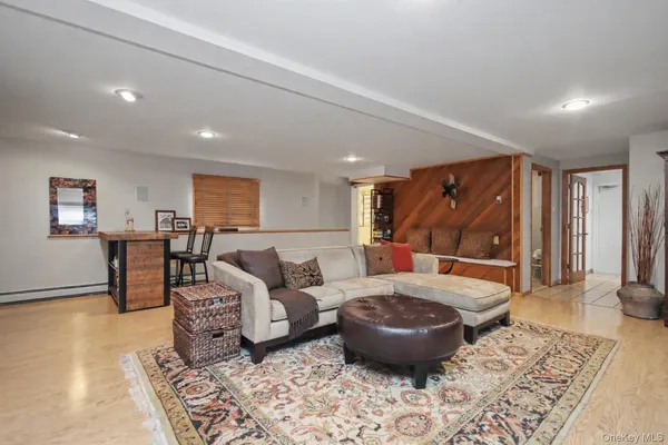 a living room with furniture a wooden floor and next to a window