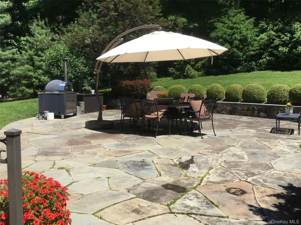 a view of a patio with a table and chairs under an umbrella
