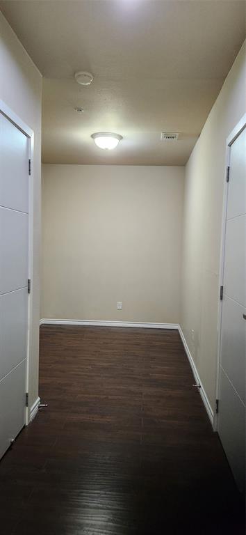 1100 West Trinity Mills Road, Unit 3003 Carrollton, TX 75006 - Photo 13 of 26 an empty room with wooden floor and windows