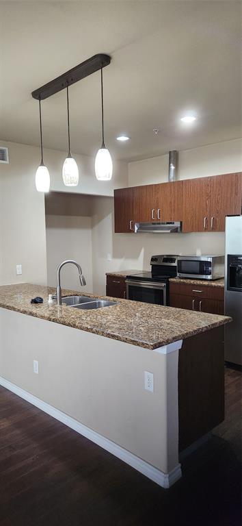 1100 West Trinity Mills Road, Unit 3003 Carrollton, TX 75006 - Photo 14 of 26 a kitchen with stainless steel appliances granite countertop a sink a stove counter space and a sink