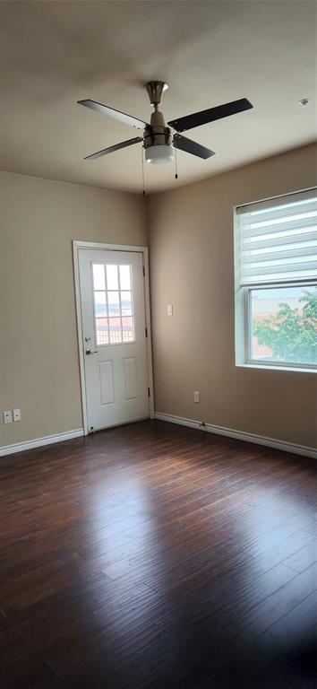 1100 West Trinity Mills Road, Unit 3003 Carrollton, TX 75006 - Photo 17 of 26 an empty room with wooden floor and windows