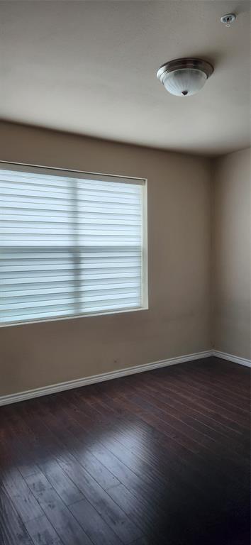 1100 West Trinity Mills Road, Unit 3003 Carrollton, TX 75006 - Photo 18 of 26 an empty room with wooden floor and windows