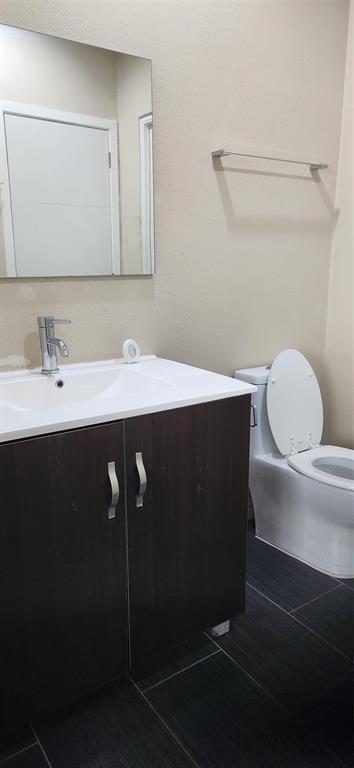 1100 West Trinity Mills Road, Unit 3003 Carrollton, TX 75006 - Photo 24 of 26 a bathroom with a sink a toilet and mirror