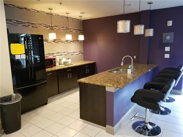 a kitchen with a sink a counter and chairs